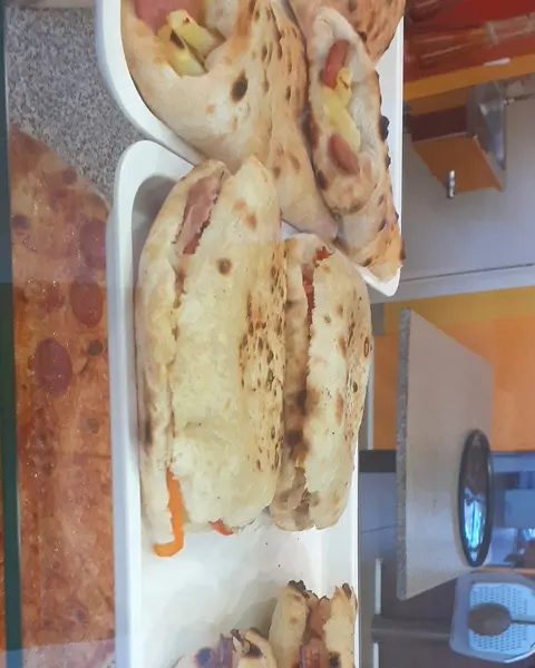 Calzoni e tranci di pizza esposti al banco